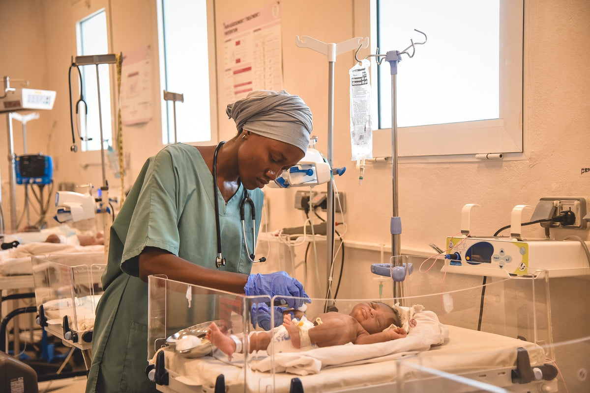 Eine Pflegekraft versorgt ein Neugeborenes in einer Klinik