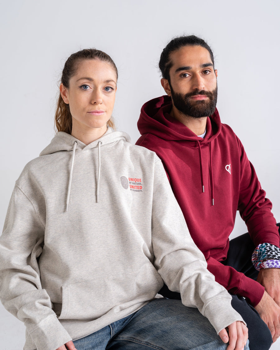 Zwei Models in Hoodies: Unique by nature in Creme meliert und Pflasterherz in Burgund